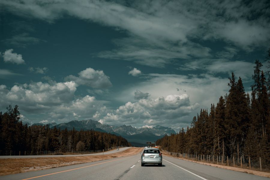 car travelling on a highway towards mountains