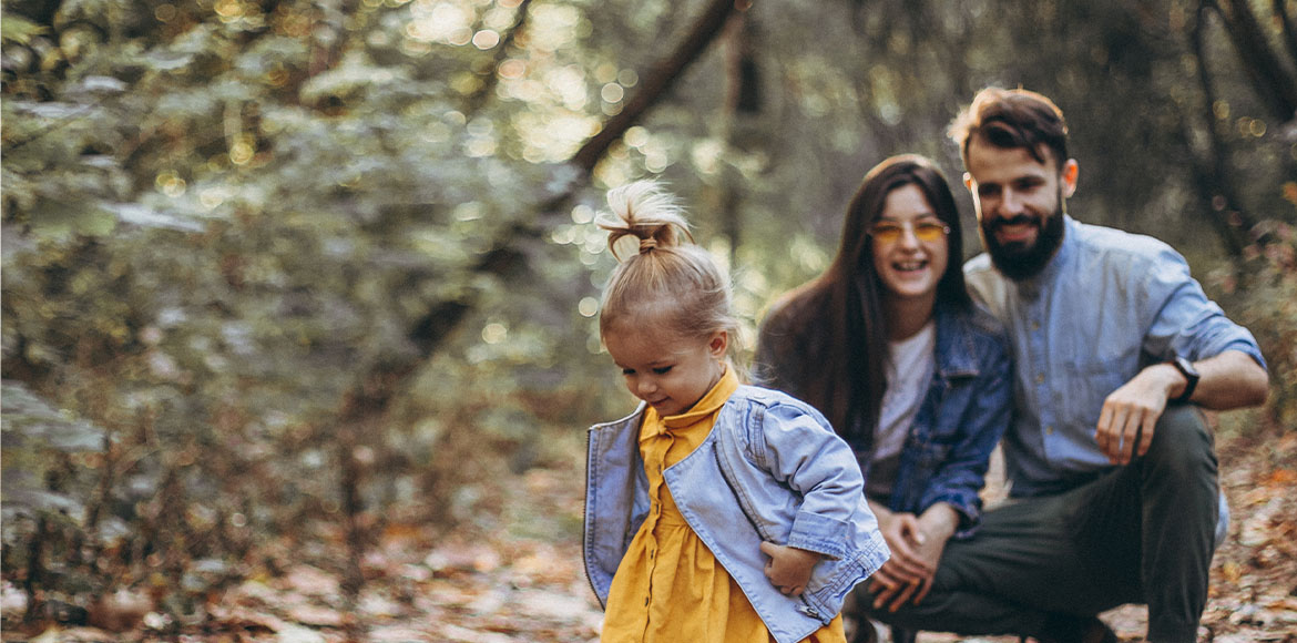 toddler and family playing in forest